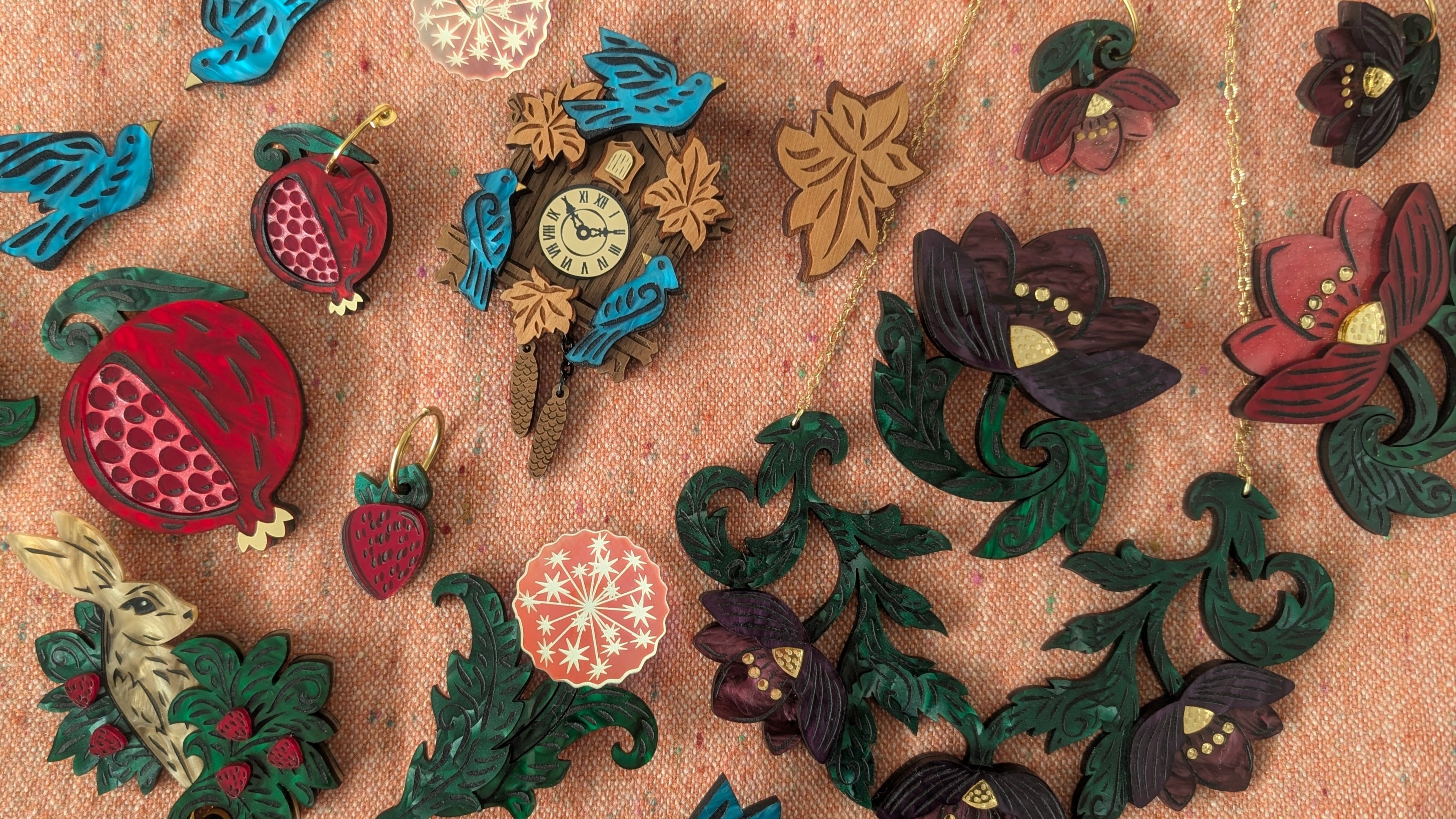 Collection of colorful brooches on a textured fabric background